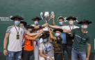 Los ocho pelotaris de Pamplona y su entrenador, Iñaki Barbajero, alzan el trofeo de campeones.