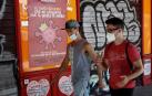 Dos jóvenes pasean con mascarilla por una calle de Madrid