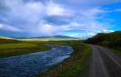 Vista de una carretera junto a un río en una zona rural
