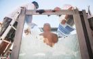 El nadador de hielo austriaco Josef Koeberl en una cabina de vidrio mientras los voluntarios la llenan con cubitos de hielo.