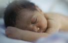 Bebé prematuro durmiendo en una incubadora. 