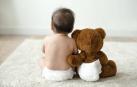 Imagen de un bebé con un osito de peluche