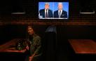 Una mujer mira el debate presidencial norteamericano en Sidney.