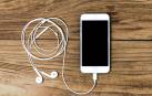 Imagen de unos auriculares conectados a un smartphone