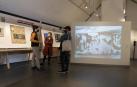 Asistentes a la inauguración de la muestra junto a una reproducción del 'Guernica' de Picasso.