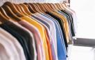Imagen de varias camisetas de colores en un carril de ropa