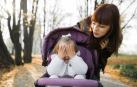 Imagen de una niña jugando con su madre en una silla de paseo