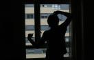 Un hombre mira por la ventana de su dormitorio.