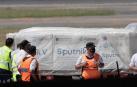 Operarios descargan un avión de Aerolíneas Argentinas contenedores de la vacuna rusa Sputnik V.