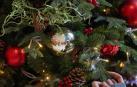 Una mujer, reflejada en la bola de un árbol navideño.