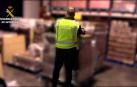 Un guardia civil examina una de las cajas de botellas de ron falsificadas