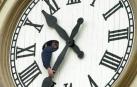 Un operario cambiando la hora de un reloj.