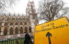 Una señal que indica un centro de vacunación, junto a la Abadía de Westminster.