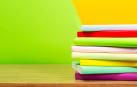 Imagen de varios libros de colores apilados en una mesa