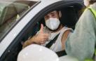 Un joven saluda después de ser vacunado en el interior de su coche.