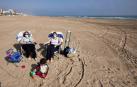 Varias personas toman el sol en la playa de Gandía.