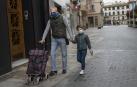 Un niño camina por la calle con su padre, ambos con mascarillas, en Tudela