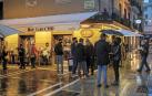 Viandantes y clientes tomando algo en la terraza del bar Gaucho, en Pamplona, en la lluviosa noche del pasado jueves.