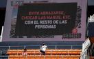 Dos aficionados en Mestalla con un mensaje a sus espaldas.