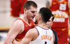 Nikola Jokic discute con Devin Booker.