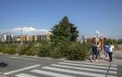 Un grupo de personas pasa por la acera de la avenida Gupúzcoa junto al solar que cobijará un cubo comercial y viviendas