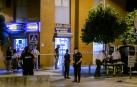 Los servicios funerarios transportan el cadáver de un hombre que ha muerto esta tarde por disparos de la Policía cuando estaba intentado atracar un supermercado de Sevilla