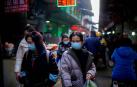 Varias personas caminan por las calles de Wuhan