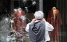 Un hombre observa un escaparate atacado durante la noche en el centro de San Sebastián