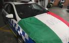 Imagen de un coche de la Policía Municipal con la bandera italiana recuperada.