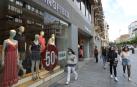 Jóvenes realizan compras por el centro de Pamplona durante el inicio de las rebajas de verano