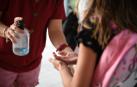 Un escolar recibe gel hidroalcohólico al llegar al aula