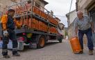Un repartidor de bombonas tradicionales de Repsol entrega una  a Javier Urabayen Gil, de 78 años, en el pueblo de Luquin (Tierra Estella)