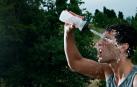 Un deportista, echándose agua