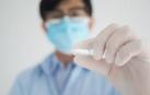 Un sanitario sostiene una pastilla de Molnupiravir