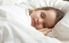 Una niña durmiendo en su cama