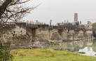 Imagen actual del puente del Ebro con numerosos restos de árboles junto a los tajamares y la Catedral, al fondo