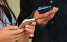 Dos personas consultan sus teléfonos móviles