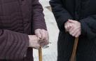 Dos señoras mayores se apoyan en sendos bastones, a las puertas del hospital Reina Sofía