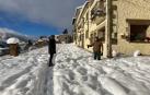Dos vecinos conversan, ayer, en la carretera de acceso a Petilla de Aragón cubierta por varios cm de nieve
