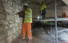 Dos operarios trabajan en los arcos del puente más cercanos al casco urbano de Tudela