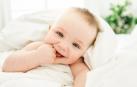 Un bebé sonríe a la cámara