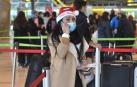 Una mujer con un gorro de Papa Noel en el aeropuerto de Adolfo Suárez, el día previo a la Nochebuena