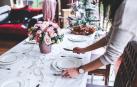 Una mujer prepara la mesa por Navidad