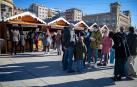 Varias personas disfrutan del último día frente a los puestos de la feria navideña de la Plaza del Castillo