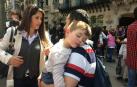 Niño dormido en brazos de un adulto junto a la Casa Batlló, en Barcelona, en 2017