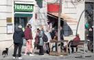Varias personas guardan cola ante una farmacia del barrio del Guinardó de Barcelona