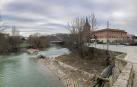 Viandantes por el puente de Santa Engracia, con el azud del mismo nombre en el río y partido por la mitad