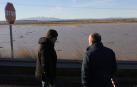 Dos personas miran campos inundados en las inundaciones de diciembre, en la zona de Valtierra