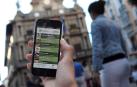 Una persona enseña una de sus aplicaciones móviles en la plaza del Ayuntamiento de Pamplona.