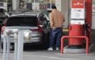 Una persona reposta combustible una gasolinera